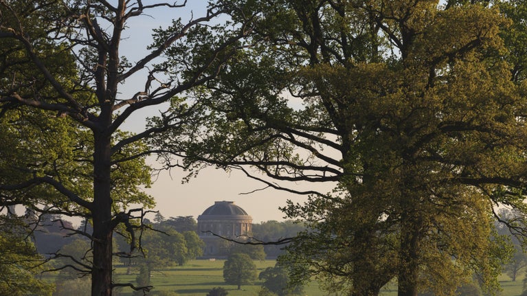 Green trees frame a Rotunda in the distance at Ickworth